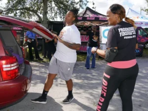 PFA Member placing a turkey in the back of a trunk